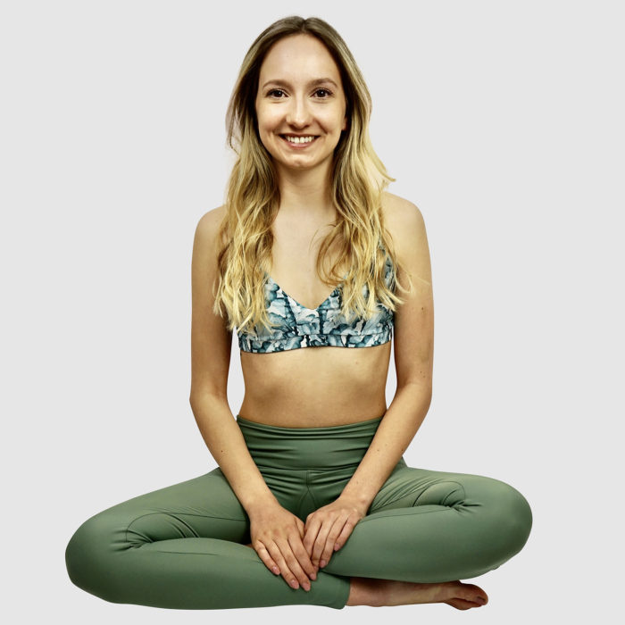 Frau in Bikinioberteil und Schwimmleggings aus nachhaltigem Material, speziell geeignet zum Surfen