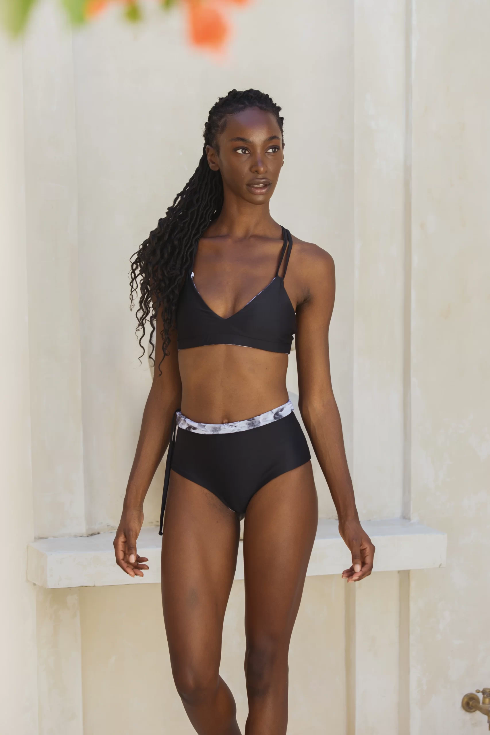 Model in schwarzem high weist Bikini aus nachhaltigem Material